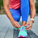 Woman tying up her shoelaces before a run.