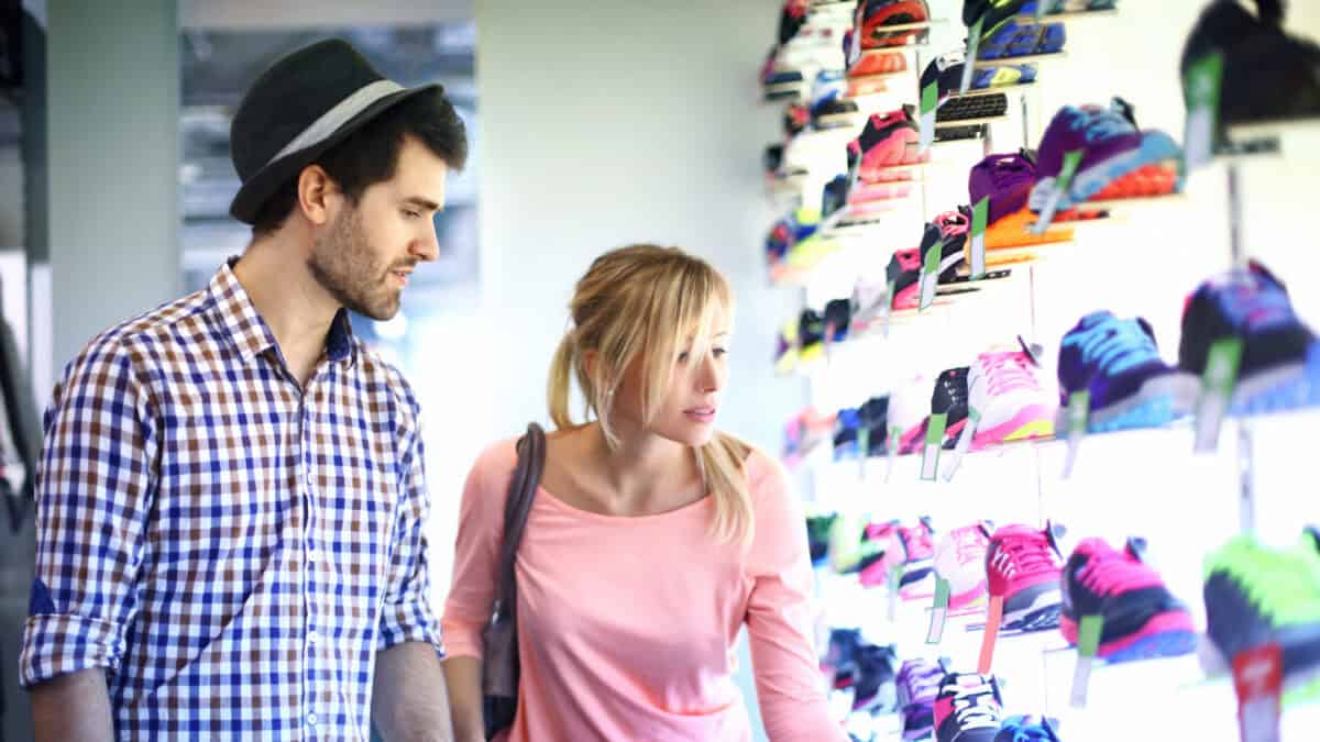 Couple checking out shoes to buy at a shop.