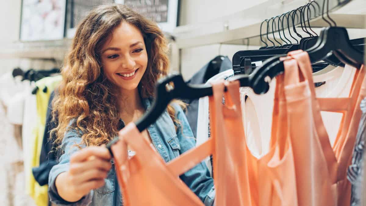 Smiling woman checking out clothes at a shop.