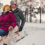 Senior couple sledding in the snow.