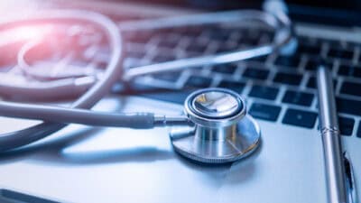Stethoscope and a pen on a laptop.