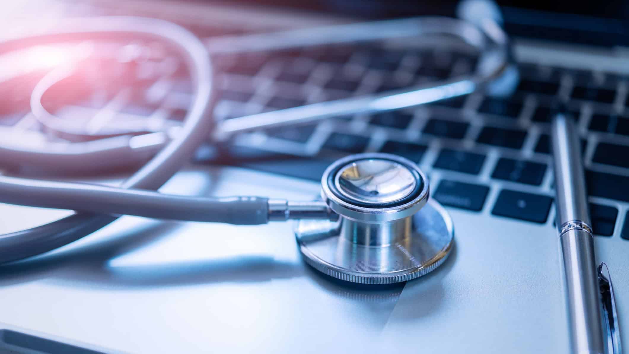 Stethoscope and a pen on a laptop.