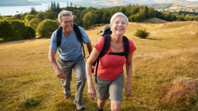 Senior couple climbing hill.