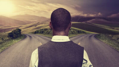 Man looking at two roads going in different directions.