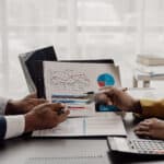 Two business partner colleagues discuss financial and company results.