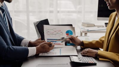 Two business partner colleagues discuss financial and company results.