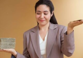 A businesswoman weighs up the stack of cash she receives, with the pile in one hand significantly more than the other hand.