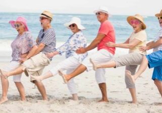 Five retirees do a conga line dance on the beach celebrating the special dividend announced by Grange Resources today